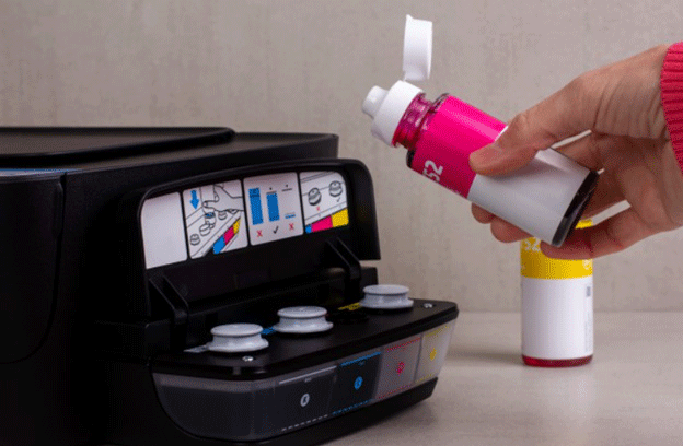 A-woman's-hand-pours-paint-from-a-bottle-into-the-printer