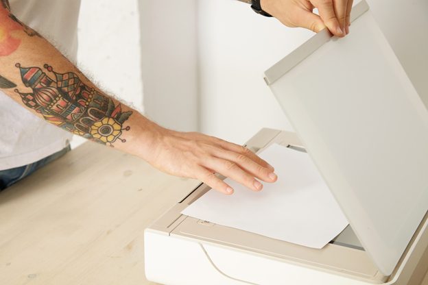 hands-open-scanner-tray-put-paper-sheet-scan-document-inside-multifunctional-electronic-device-isolated-white-wooden-table